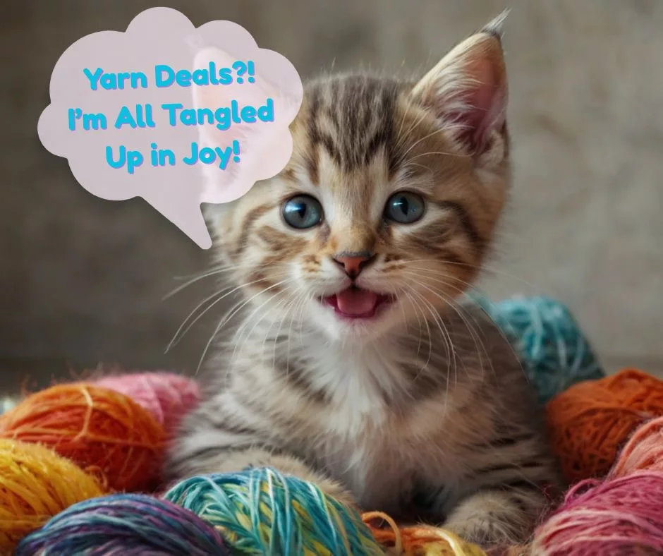 Tabby kitten with blue eyes sitting among colorful yarn balls, looking excited with mouth open—featured image for blog post on best yarn deals from Prime Day 2025.