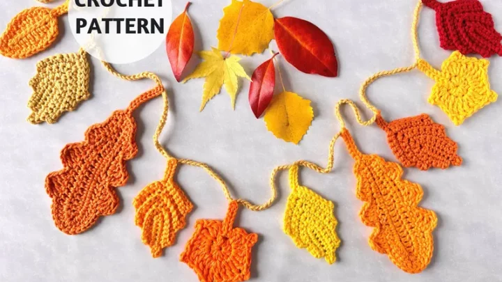 Collage of colorful crocheted autumn leaves in yellow, orange, and red resting on a wooden surface.
