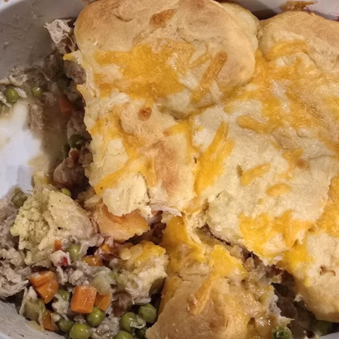 Easy chicken pot pie with creamy chicken and vegetables beneath golden baked biscuits.